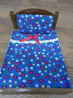 Sylvanian Double bed royal blue background with red,white and yellow flowers.Has white lace trim and a red bow on the front.A matching pillow to complete the set.