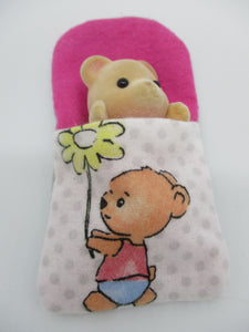 Sylvanian Families Sleeping bag with teddy bear holding a daisy flower on the front,lined on the inside with pink fabric.
